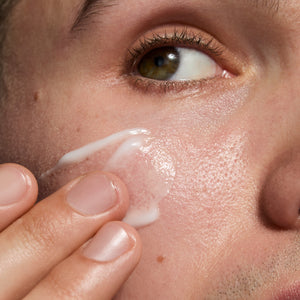 Close-up of a person applying Omega Water cream to their face