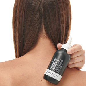 Glycolic Acid Exfoliating Scalp Scrub bottle held by model