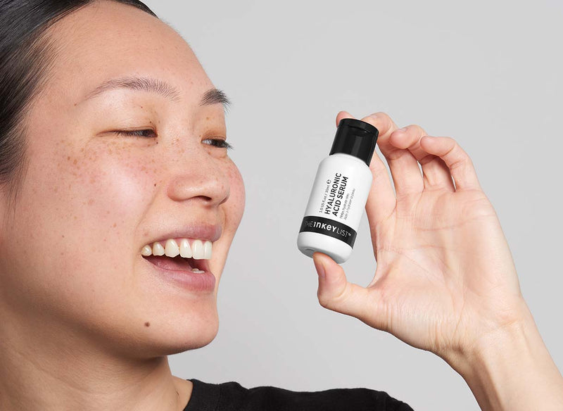 Model holding Hyaluronic Acid Serum bottle