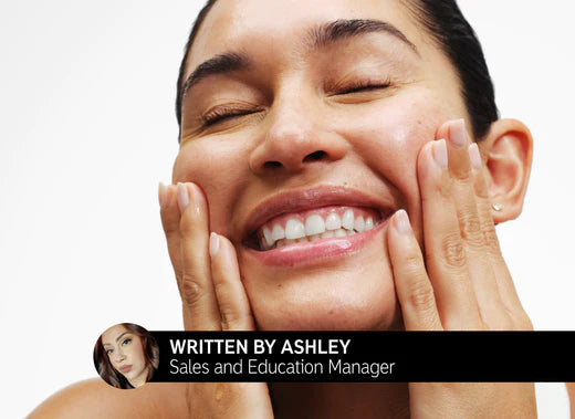 Model smiling whilst applying skincare