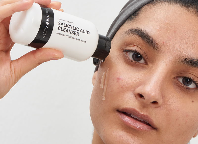Model pouring Salicylic Acid Cleanser on her face