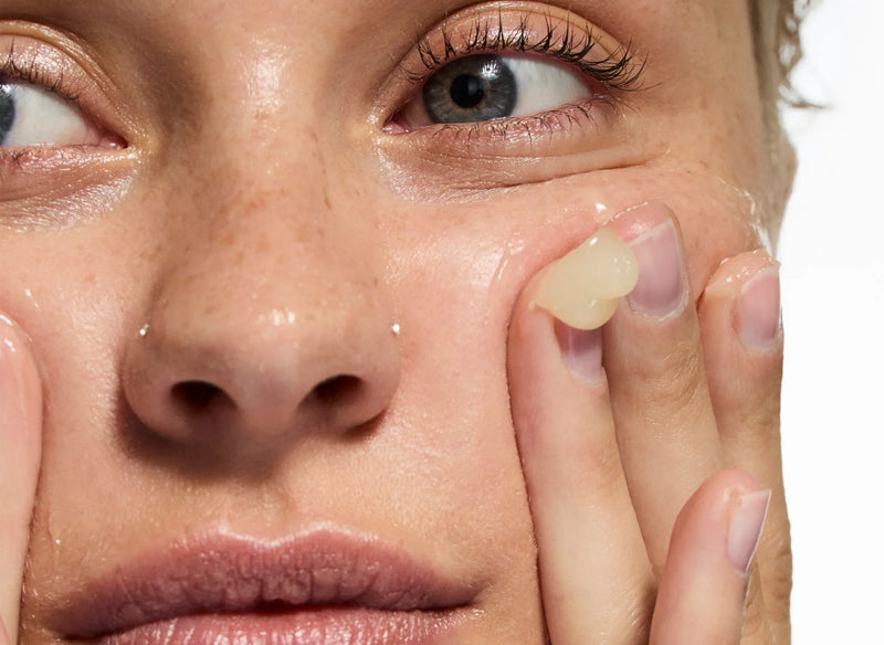 Woman applying Oat Cleansing Balm to her face