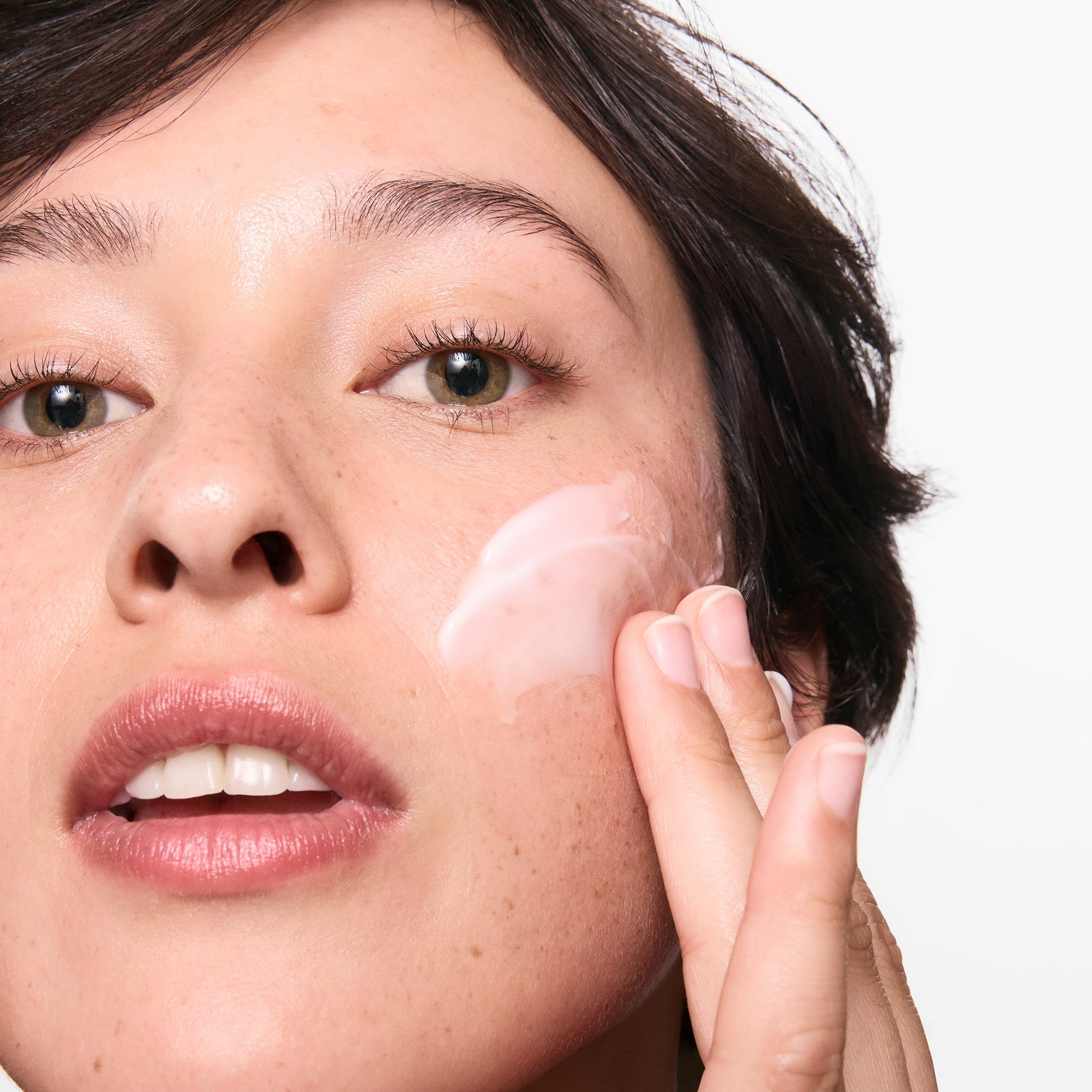 Model applying omega water cream to her face