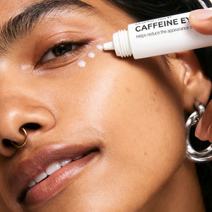 Model applying caffeine eye cream