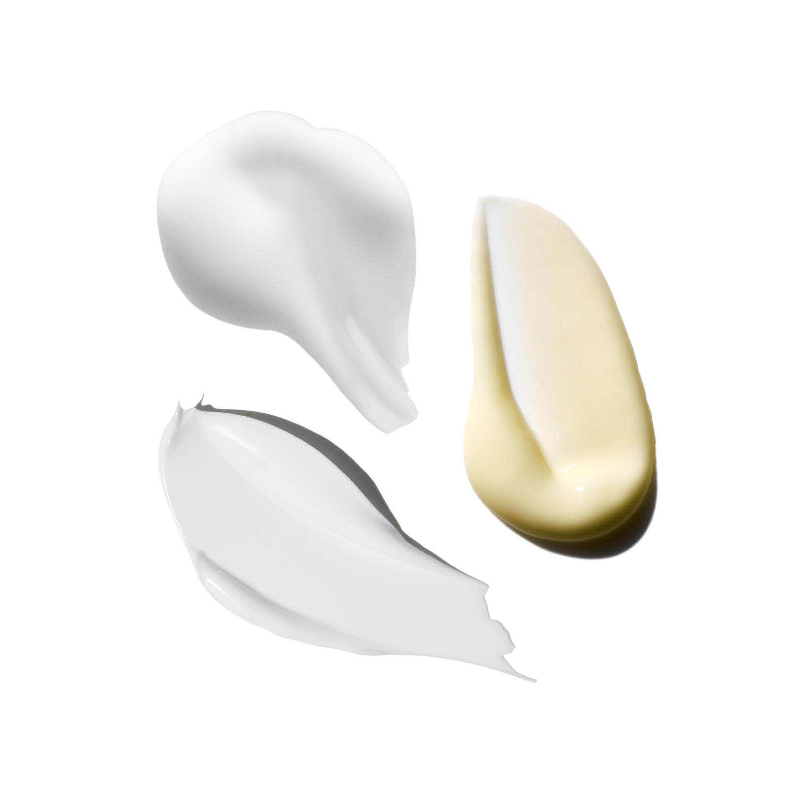 Three swatches of cream in white, beige, and gray on a white background