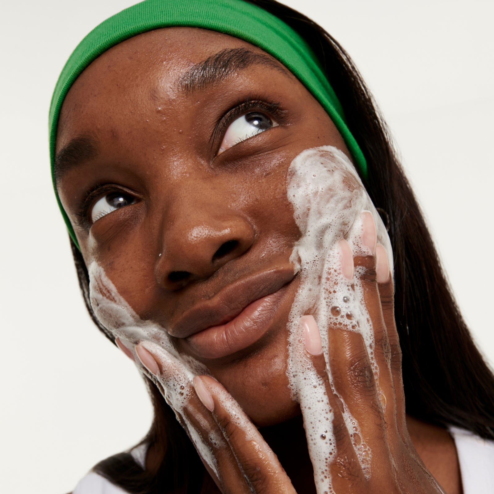 Woman washing her face with cleanser