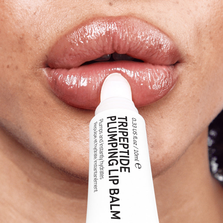 Model applying The INKEY List's Tripeptide Plumping Lip Balm