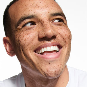Close-up of a person with a bright smile on a white background