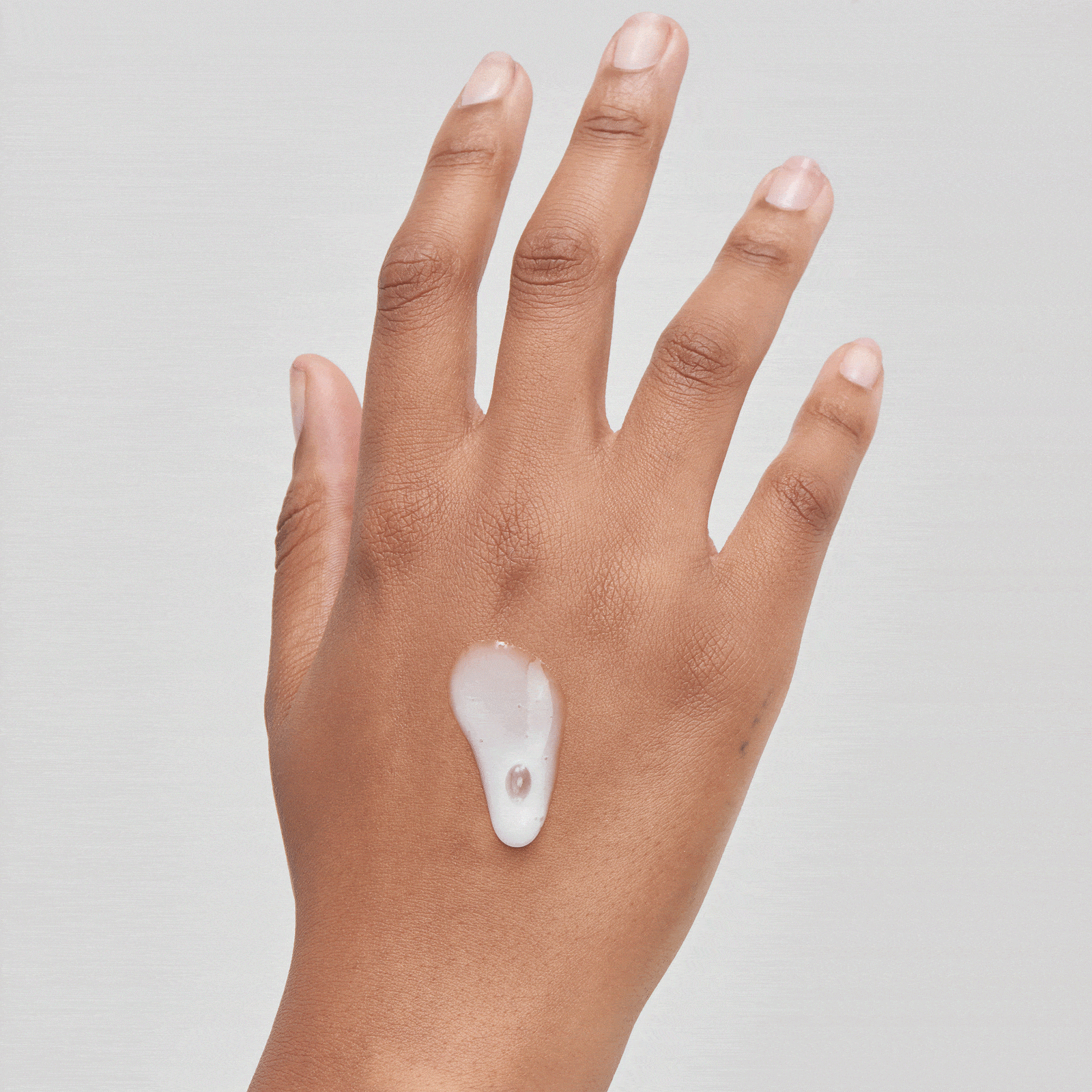 Alpha Arbutin GIF showing product on the back of model's hand