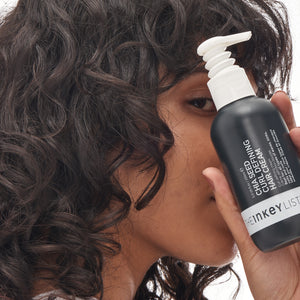 Chia seed curl defining hair treatment model holding bottle 