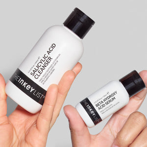 Deep Cleanse Duo bottles being held against a grey background